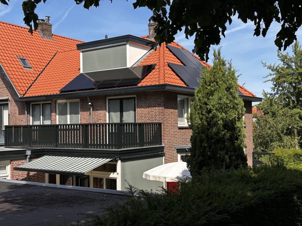 Hollanda'da kiremitli eğimli bir çatıya yapılmış siyah panelli güneş enerjisi kurulumu
