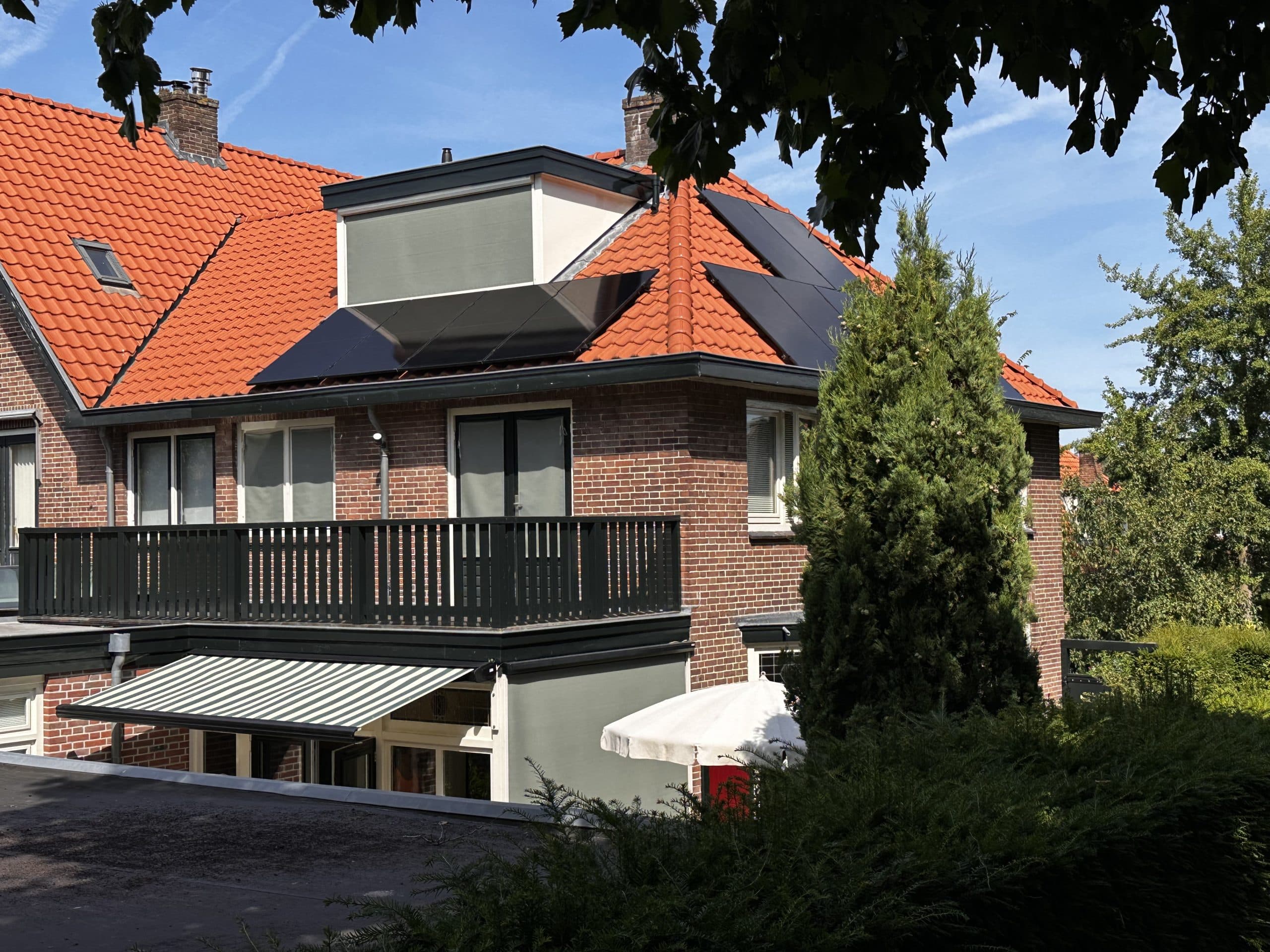 Hollanda'da kiremitli eğimli bir çatıya yapılmış siyah panelli güneş enerjisi kurulumu